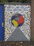 905480 Afbeelding van het kleurrijke mozaïek met de tekst 'DOOR HET KIND NAAR EEN NIEUWE VREEDZAME WERELD', naast een ...
